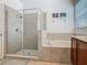Modern bathroom featuring tiled shower with glass door, and a separate soaking tub at 2860 Orange Haven Way, Kissimmee, FL 34746
