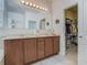 Bathroom featuring double vanity, large mirror, and walk-in closet at 2860 Orange Haven Way, Kissimmee, FL 34746