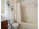 This bathroom includes a toilet, tub and shower with a white shower curtain, and decorative mirrors on the walls at 2860 Orange Haven Way, Kissimmee, FL 34746