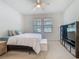 The Primary bedroom boasts two large windows, lots of light, and a black shelf against the wall at 2860 Orange Haven Way, Kissimmee, FL 34746