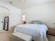 Bright bedroom with a large bed, a white bench, a small table, and a view into the en-suite bathroom at 2860 Orange Haven Way, Kissimmee, FL 34746