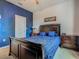 This bedroom includes a queen bed with a dark wood frame, two matching bedside tables and an overhead fan at 2860 Orange Haven Way, Kissimmee, FL 34746