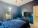 Bedroom featuring a sleek, wall-mounted TV, complemented by a cozy bed and a view to the outdoors at 2860 Orange Haven Way, Kissimmee, FL 34746