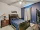 This bedroom boasts a ceiling fan, a dark wood bed frame and a nightstand on each side at 2860 Orange Haven Way, Kissimmee, FL 34746