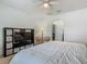 This bedroom has a bed, storage shelves with a television, a ceiling fan, and an open door into the en-suite bathroom at 2860 Orange Haven Way, Kissimmee, FL 34746