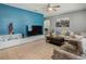 Bright living room with stylish decor, featuring a large TV, comfortable seating, and a blue accent wall at 2860 Orange Haven Way, Kissimmee, FL 34746