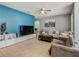 Well-lit living room with tile floors, a blue accent wall, and comfortable seating arrangements, perfect for relaxation at 2860 Orange Haven Way, Kissimmee, FL 34746