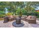 Inviting backyard patio featuring cozy seating around a modern fire pit for outdoor relaxation at 33919 Terragona Dr, Sorrento, FL 32776