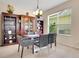 Formal dining room with a modern glass table, decorative shelving and natural light at 33919 Terragona Dr, Sorrento, FL 32776