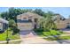 Two-story home with a two-car garage, brick driveway, manicured lawn and lovely landscaping at 33919 Terragona Dr, Sorrento, FL 32776