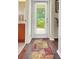 Bright hallway with bathroom and backyard access, featuring a colorful rug on hardwood floors at 33919 Terragona Dr, Sorrento, FL 32776