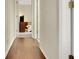 Hallway with hardwood flooring leading to a bedroom with a comfortable bed and dresser at 33919 Terragona Dr, Sorrento, FL 32776