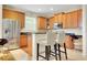 Kitchen with stainless steel appliances, granite counters, wooden cabinetry and bar stool seating at 33919 Terragona Dr, Sorrento, FL 32776