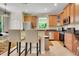 Bright kitchen with stainless steel appliances, wood cabinets, granite countertops, and bar stool seating at 33919 Terragona Dr, Sorrento, FL 32776