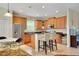 Bright kitchen featuring stainless steel appliances, wood cabinets, granite countertops, and bar stool seating at 33919 Terragona Dr, Sorrento, FL 32776