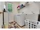 A tidy laundry room featuring a washer, dryer, sink, and storage solutions at 33919 Terragona Dr, Sorrento, FL 32776