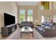 Elegant living room with two story ceiling, plush leather sofas, and many windows at 33919 Terragona Dr, Sorrento, FL 32776