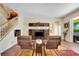 A cozy living area featuring a staircase, modern entertainment center, and comfortable seating on a colorful rug at 33919 Terragona Dr, Sorrento, FL 32776