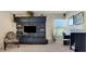 Home office area featuring a sleek entertainment center and a functional workspace with natural light at 33919 Terragona Dr, Sorrento, FL 32776