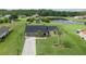 Aerial view of a home with a large yard, a pond, shed, and mature landscaping at 3600 Fountainbleu Blvd, Kissimmee, FL 34746