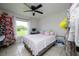 A well-lit bedroom space with tile flooring, a ceiling fan, and decoratively adorned with a festive Christmas tree at 3600 Fountainbleu Blvd, Kissimmee, FL 34746