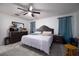 This spacious bedroom features neutral paint, a ceiling fan, a dresser and large window providing ample light at 3600 Fountainbleu Blvd, Kissimmee, FL 34746