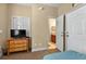 Well-lit bedroom showcases a dresser and TV, with an ensuite bathroom and closet nearby at 3725 Calabria Ave, Davenport, FL 33897