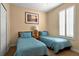Comfortable bedroom featuring two twin beds, shuttered window, and neutral walls at 3725 Calabria Ave, Davenport, FL 33897