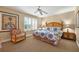 Bright bedroom features a ceiling fan, large windows with shutters, and a decorative seating chair at 3725 Calabria Ave, Davenport, FL 33897
