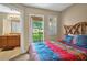 Bedroom with a bright bedspread and bathroom access, and access to a balcony at 3725 Calabria Ave, Davenport, FL 33897
