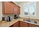 Cozy kitchen with granite countertops, stainless steel sink, and window with shutter at 3725 Calabria Ave, Davenport, FL 33897