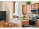 Modern kitchen featuring granite countertops, stainless steel appliances, a breakfast bar and wooden cabinetry at 3725 Calabria Ave, Davenport, FL 33897
