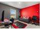A bedroom with grey walls, a red accent wall, a sofa, and a desk at 391 Begonia Ct, Kissimmee, FL 34759