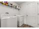 A laundry room with a washer, dryer, and shelves for storage at 391 Begonia Ct, Kissimmee, FL 34759