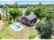 Aerial view of a two-story house with in-ground pool and large trees at 4055 State Road 11, Deland, FL 32724