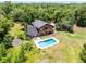 Aerial view of a wooded property featuring a house with a balcony and a backyard swimming pool at 4055 State Road 11, Deland, FL 32724