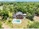 Aerial view of a wooded property featuring a house with a balcony and a backyard swimming pool at 4055 State Road 11, Deland, FL 32724