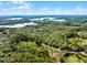 Scenic aerial view of a winding road through dense forest landscape with a picturesque lake at 4055 State Road 11, Deland, FL 32724