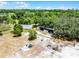 Aerial view features a greenhouse, building, and open lot area surrounded by lush, dense trees at 4055 State Road 11, Deland, FL 32724