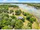 Aerial view showcases a cozy home with a pool, surrounded by lush green trees and vegetation at 4055 State Road 11, Deland, FL 32724