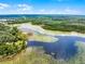 Scenic aerial view of a lake with lily pads, surrounded by green trees and a clear blue sky at 4055 State Road 11, Deland, FL 32724