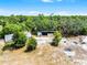 Aerial view showcases a greenhouse, building, and open area surrounded by lush green trees at 4055 State Road 11, Deland, FL 32724