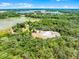 Aerial view capturing a house surrounded by a large open lot surrounded by lush, dense forest landscape at 4055 State Road 11, Deland, FL 32724