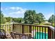 Backyard view from deck featuring pool, lake, green grass, mature trees and outdoor seating at 4055 State Road 11, Deland, FL 32724