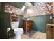 Unique bathroom with floral wallpaper, wood-paneled walls, and vintage-style fixtures at 4055 State Road 11, Deland, FL 32724