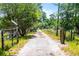 Picturesque entrance with gated driveway, lined by mature trees and lush greenery at 4055 State Road 11, Deland, FL 32724