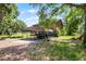Exterior view of home featuring carport with vehicles, mature trees and chickens at 4055 State Road 11, Deland, FL 32724