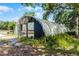 Exterior view of a greenhouse bordered by lush greenery, presenting a tranquil gardening space at 4055 State Road 11, Deland, FL 32724