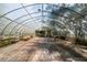 Expansive greenhouse interior with a table, shelves, and ample natural light offers opportunities for cultivation at 4055 State Road 11, Deland, FL 32724