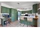 Charming kitchen with green cabinets, breakfast bar seating, and ample counter space, creating a functional and inviting cooking area at 4055 State Road 11, Deland, FL 32724